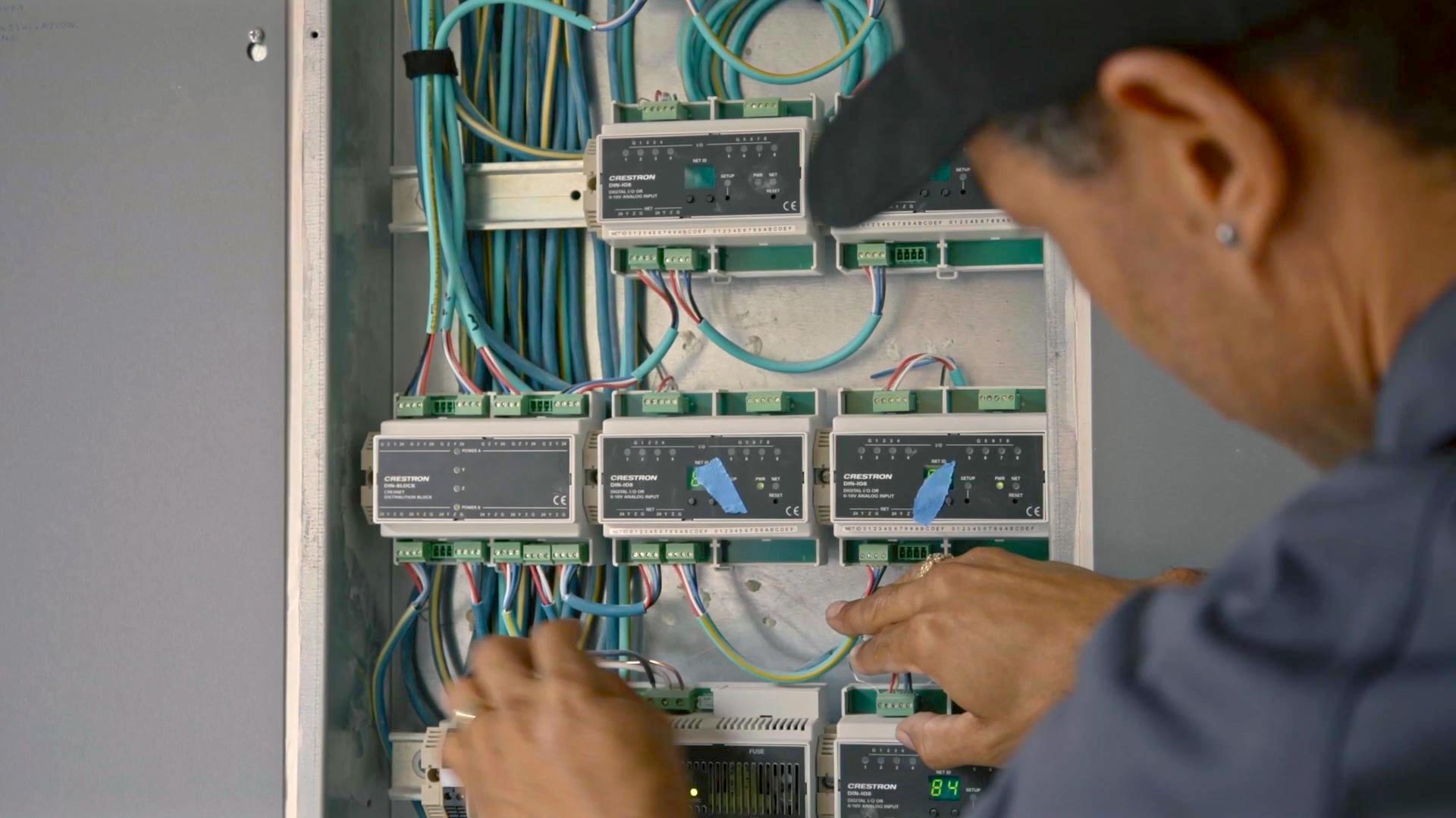 Technician wiring and configuring an electrical panel
