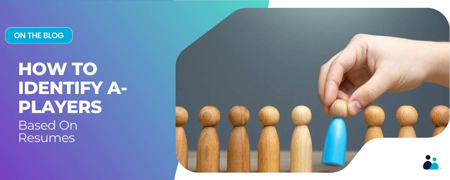 A hand selecting a blue wooden figure from a row of neutral-colored wooden figures.