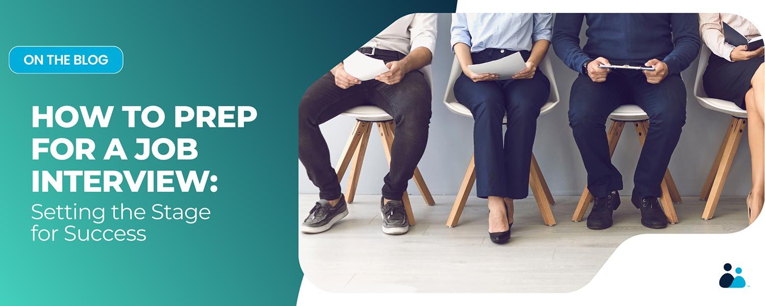 Four job candidates sitting in a row, holding resumes or tablets while waiting for an interview.